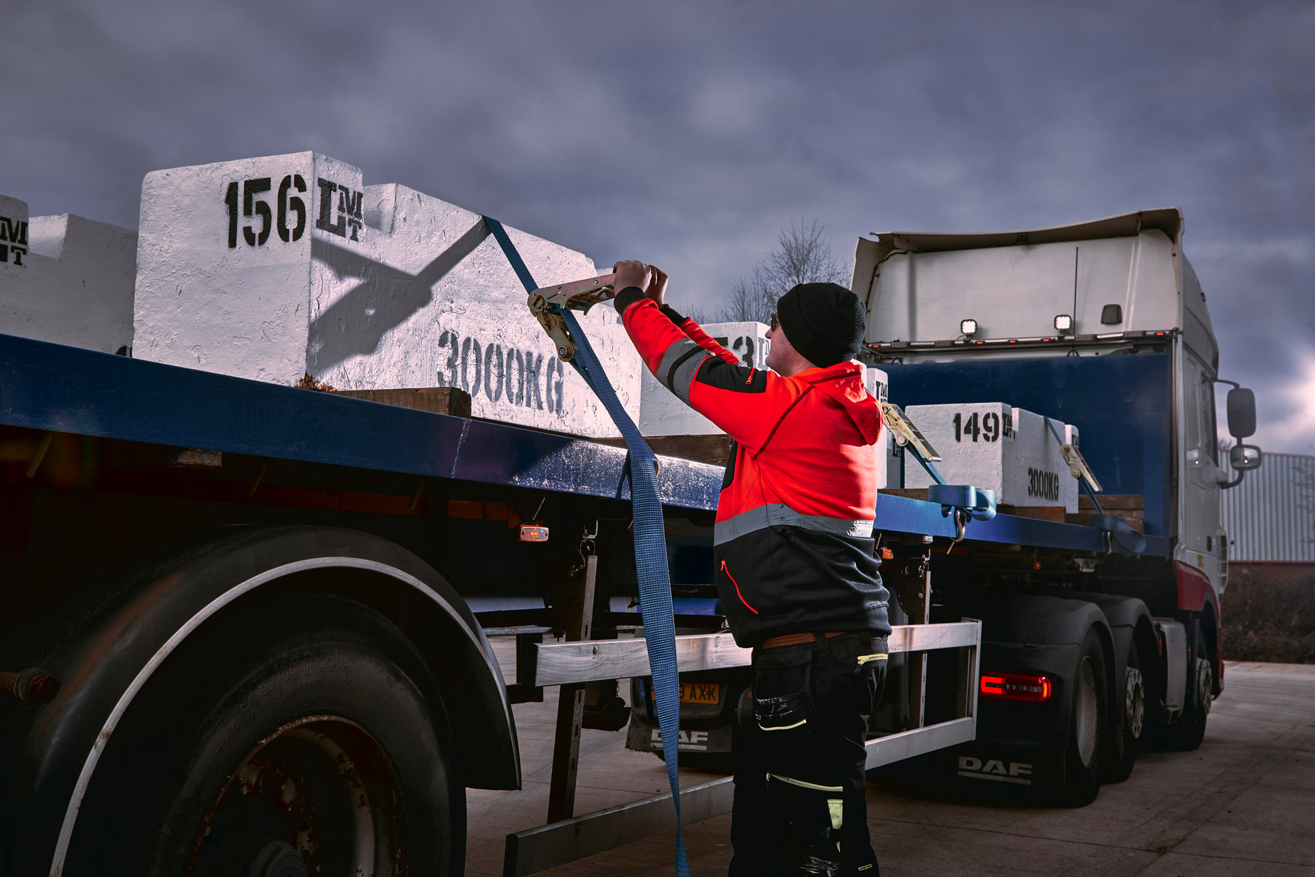 Worker checking the straps on his trailer load ready for transport